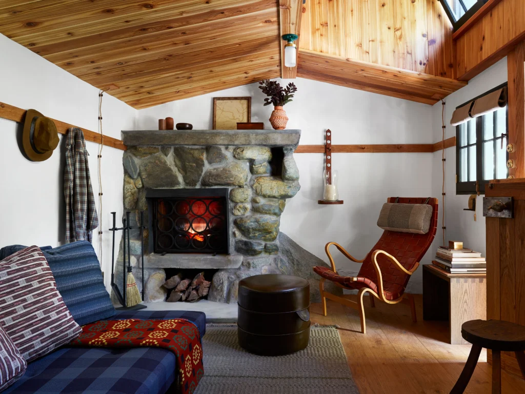 Rustic Enneagram Nine interior design style with a cozy cabin living room and stone fireplace