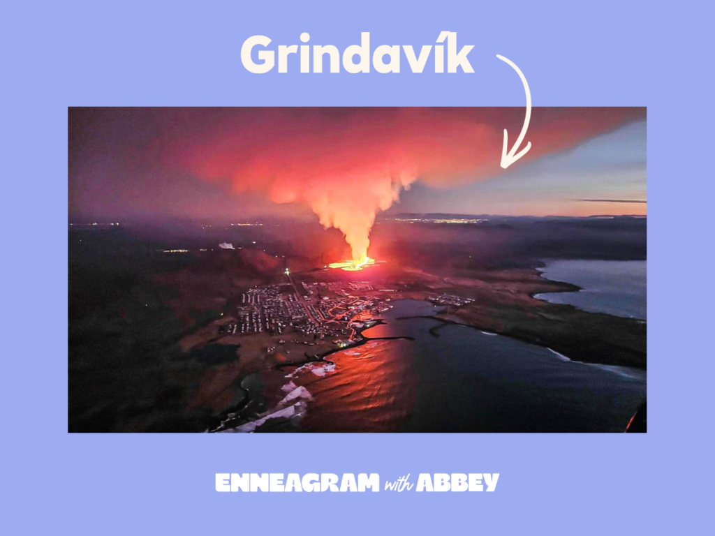 Aerial photo of the volcanic eruption near Grindavík, Iceland, with bright orange lava and a towering plume of smoke rising into the sky. White text reads "Grindavík," with a hand-drawn arrow pointing toward the town. "Enneagram with Abbey" branding appears at the bottom.